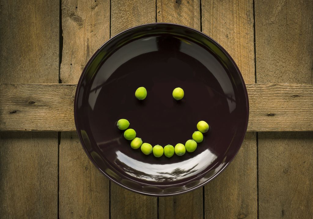 Limes on a plate in the shape of a smiley face.