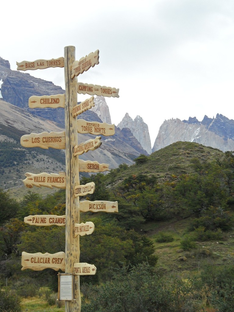 Images shows a landscape view of Patagonia, Chile, with a signpost to the lefthand foreground showing lots of different place names pointing in different directions.

Image by Katrin Schulz/Backpackerin from Pixabay