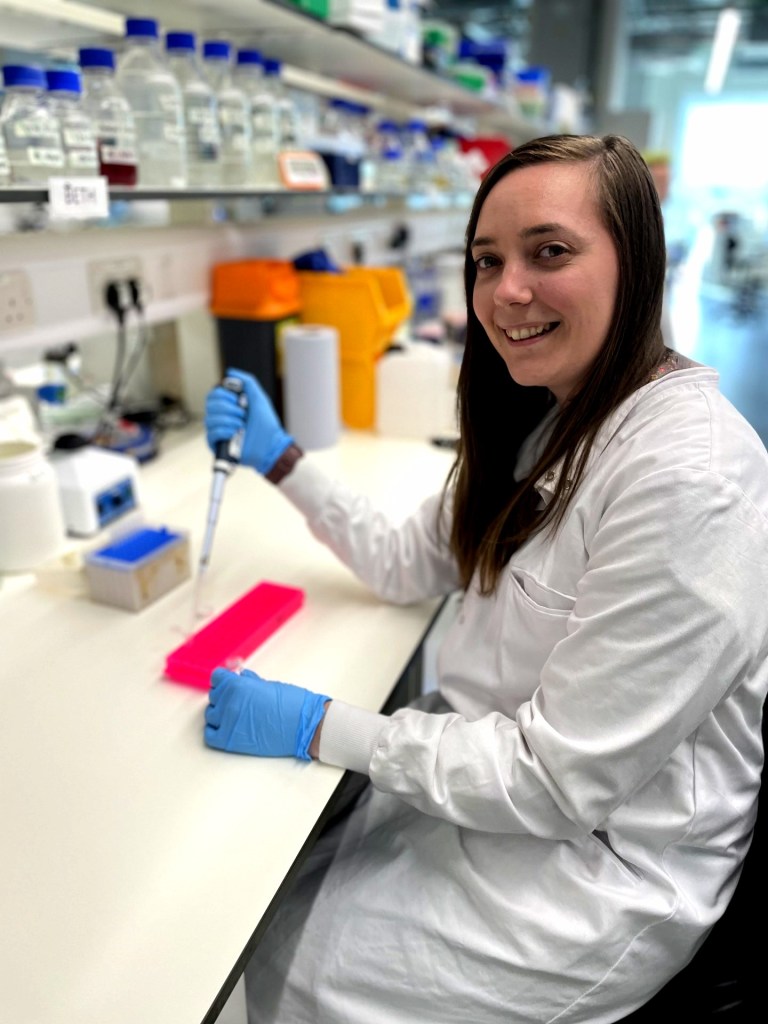 Beth at the lab bench pipetting.